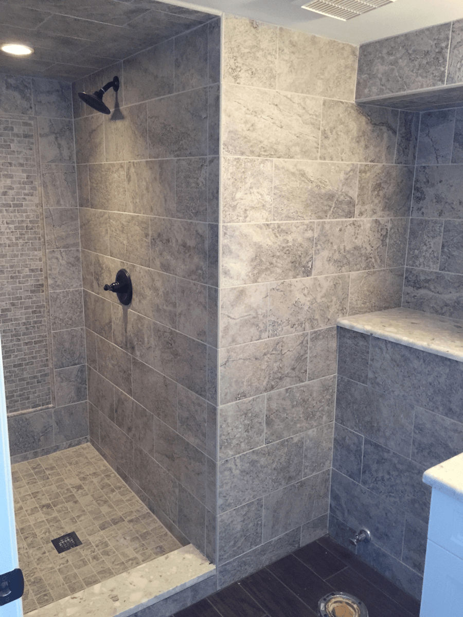 A bathroom with a walk in shower and a sink.