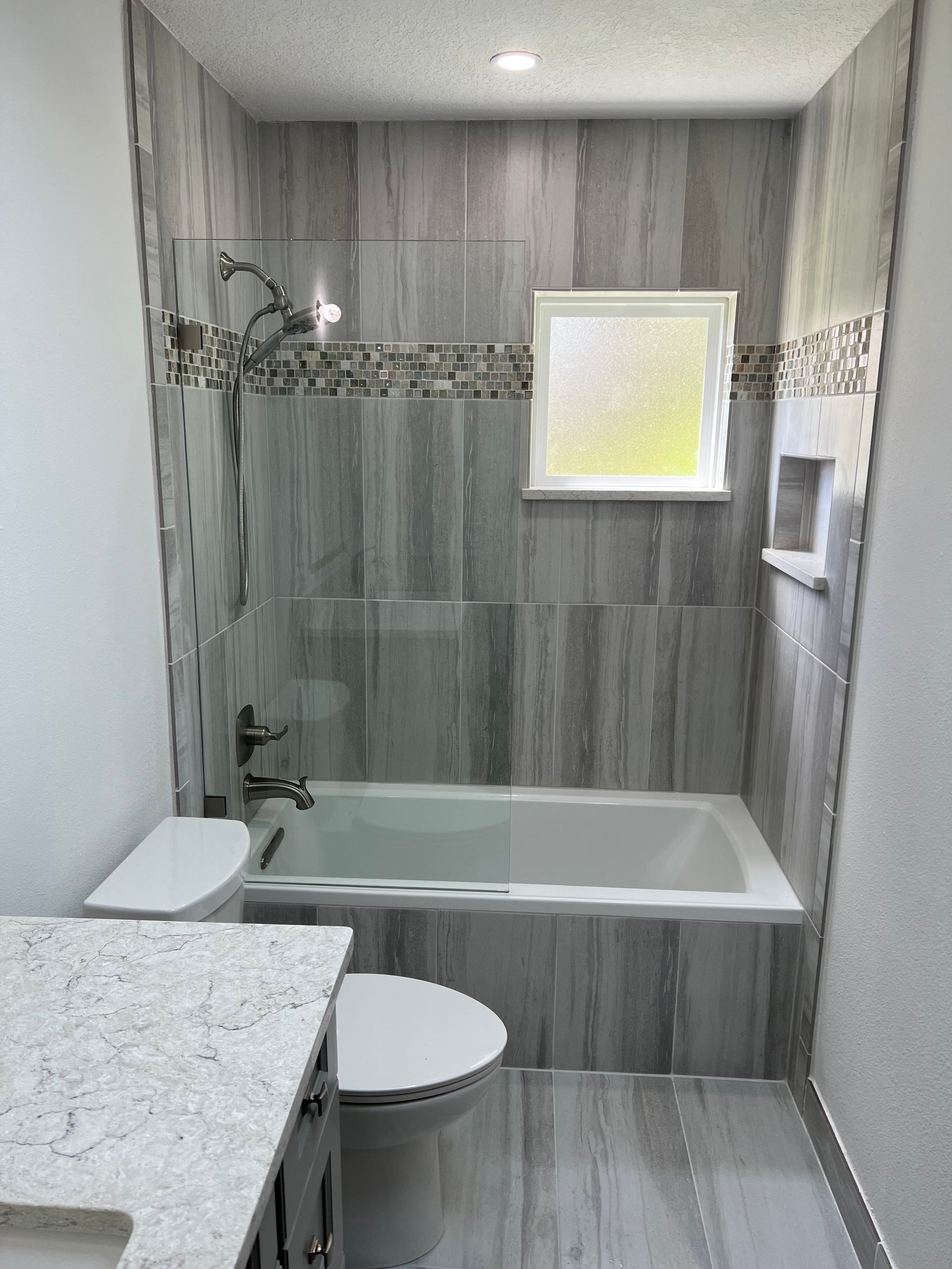 A bathroom with a tub, toilet, sink and shower.