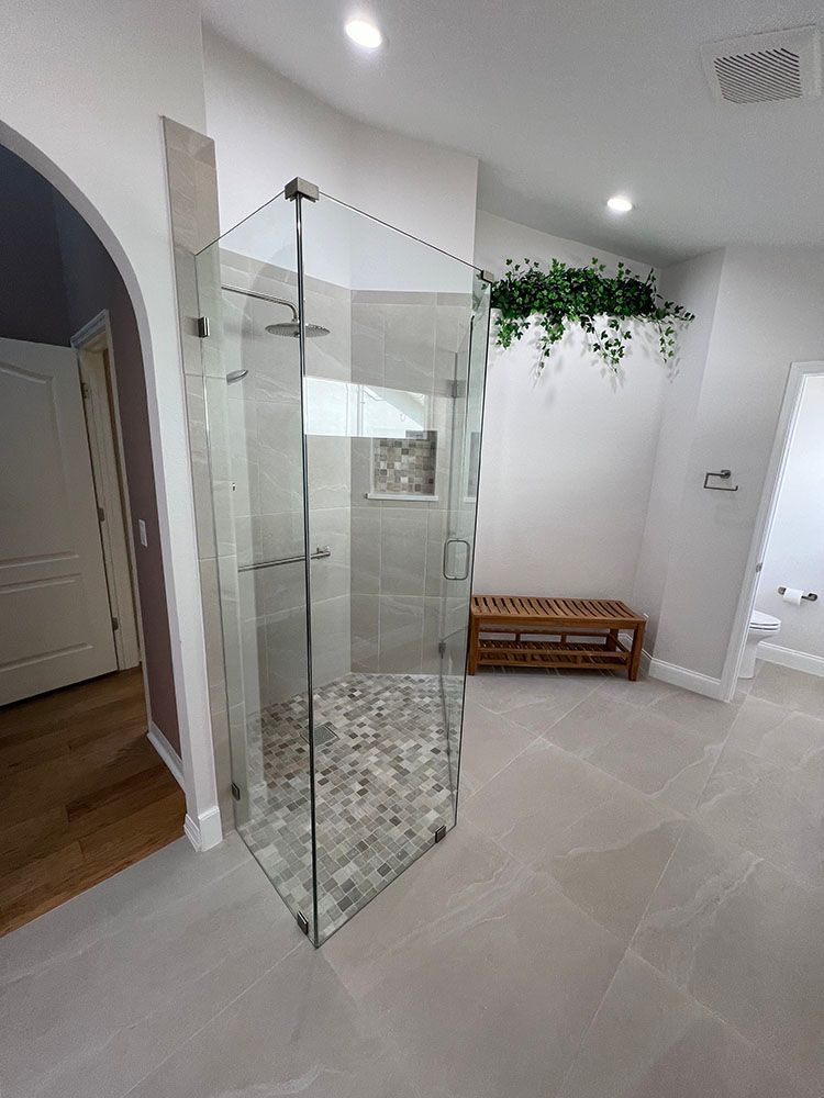 A bathroom with a walk in shower and a bench