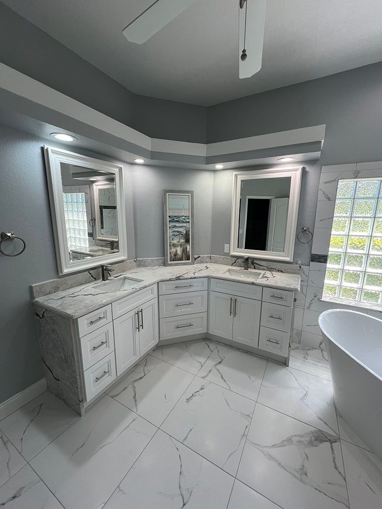 A bathroom with two sinks, two mirrors and a bathtub