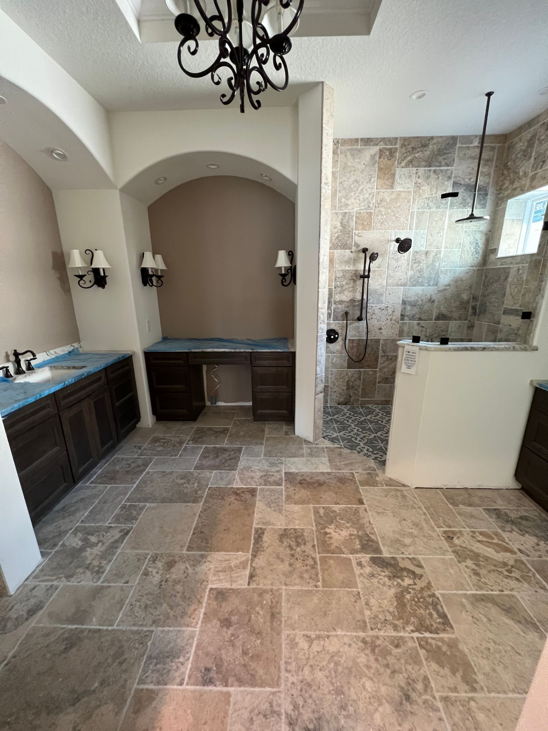A bathroom with a walk in shower and a sink.