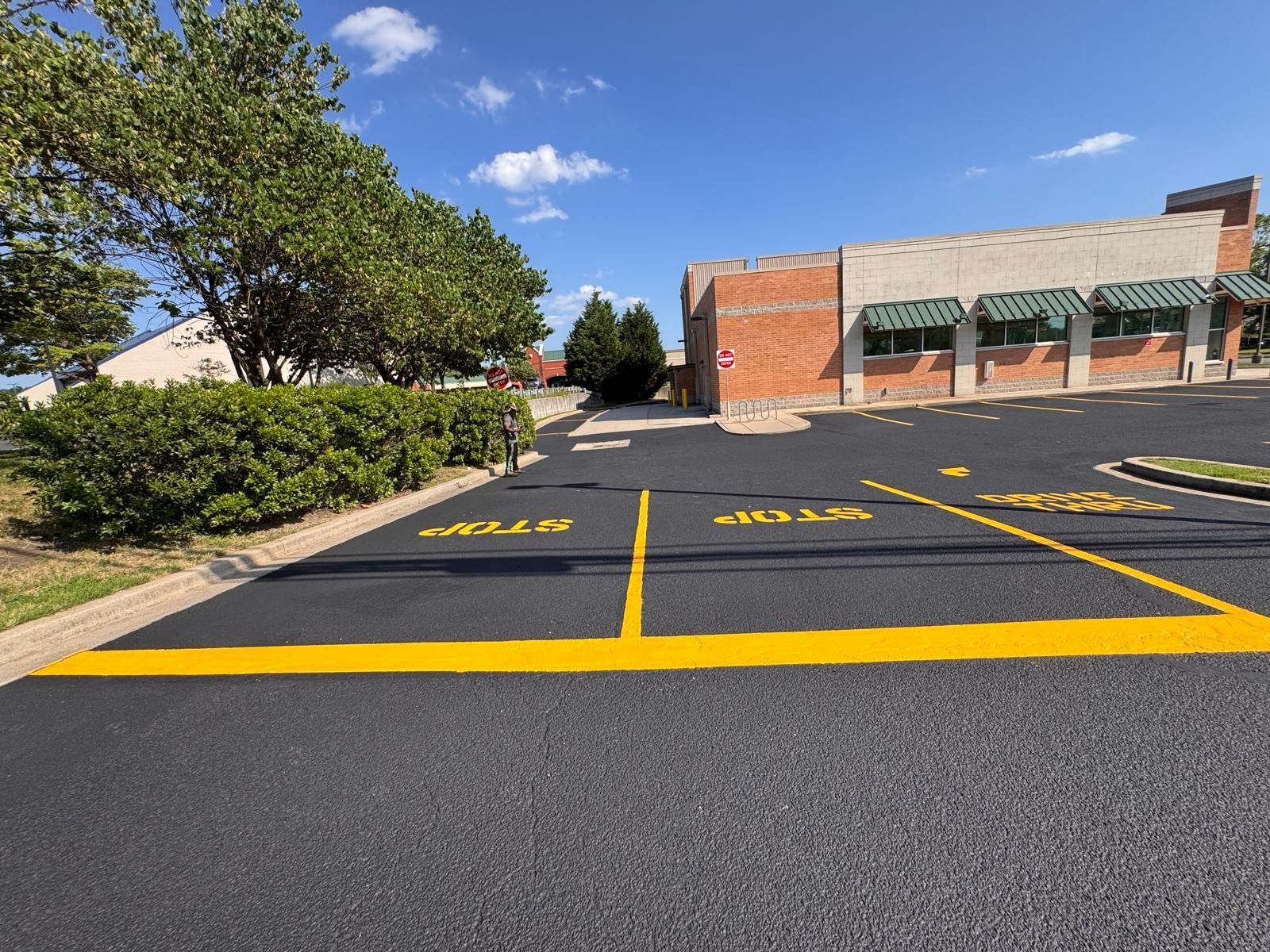 Empty accessible parking spaces marked in yellow outside a brick building on a sunny day