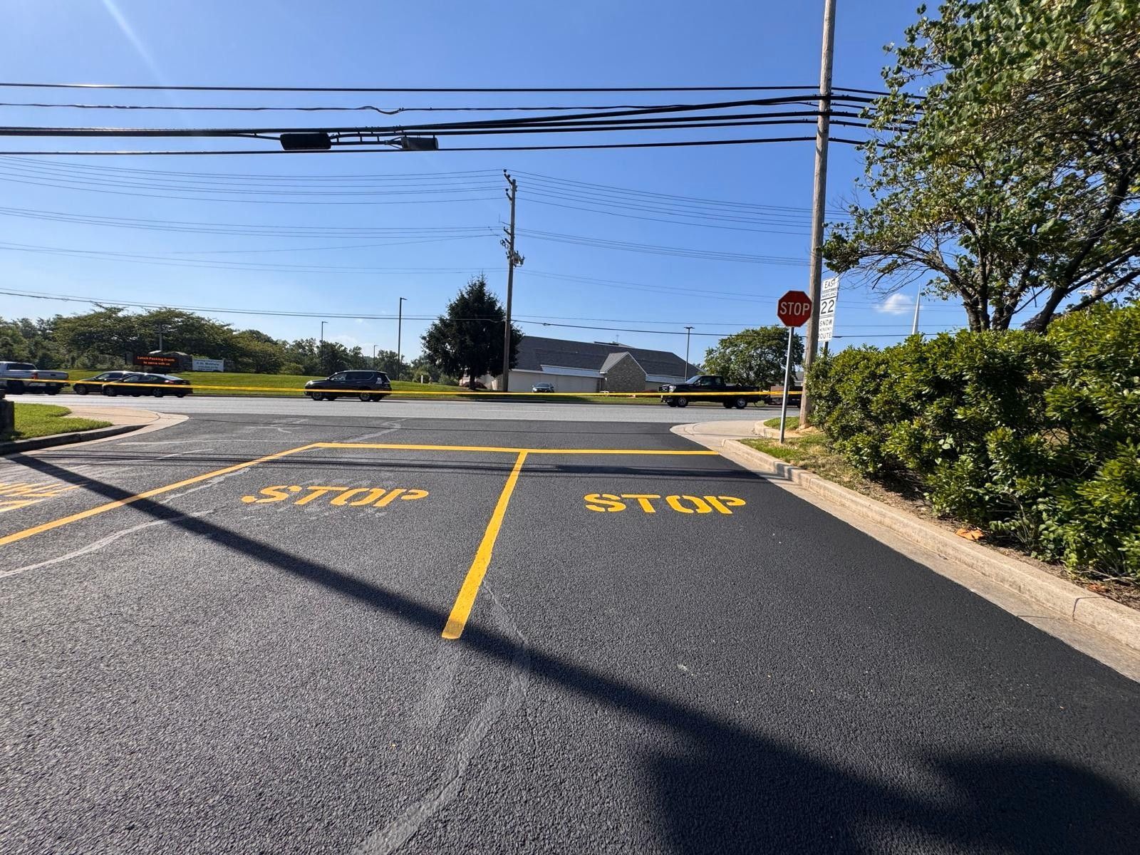 Empty parking lot with yellow stalls and stop sign under a clear sky