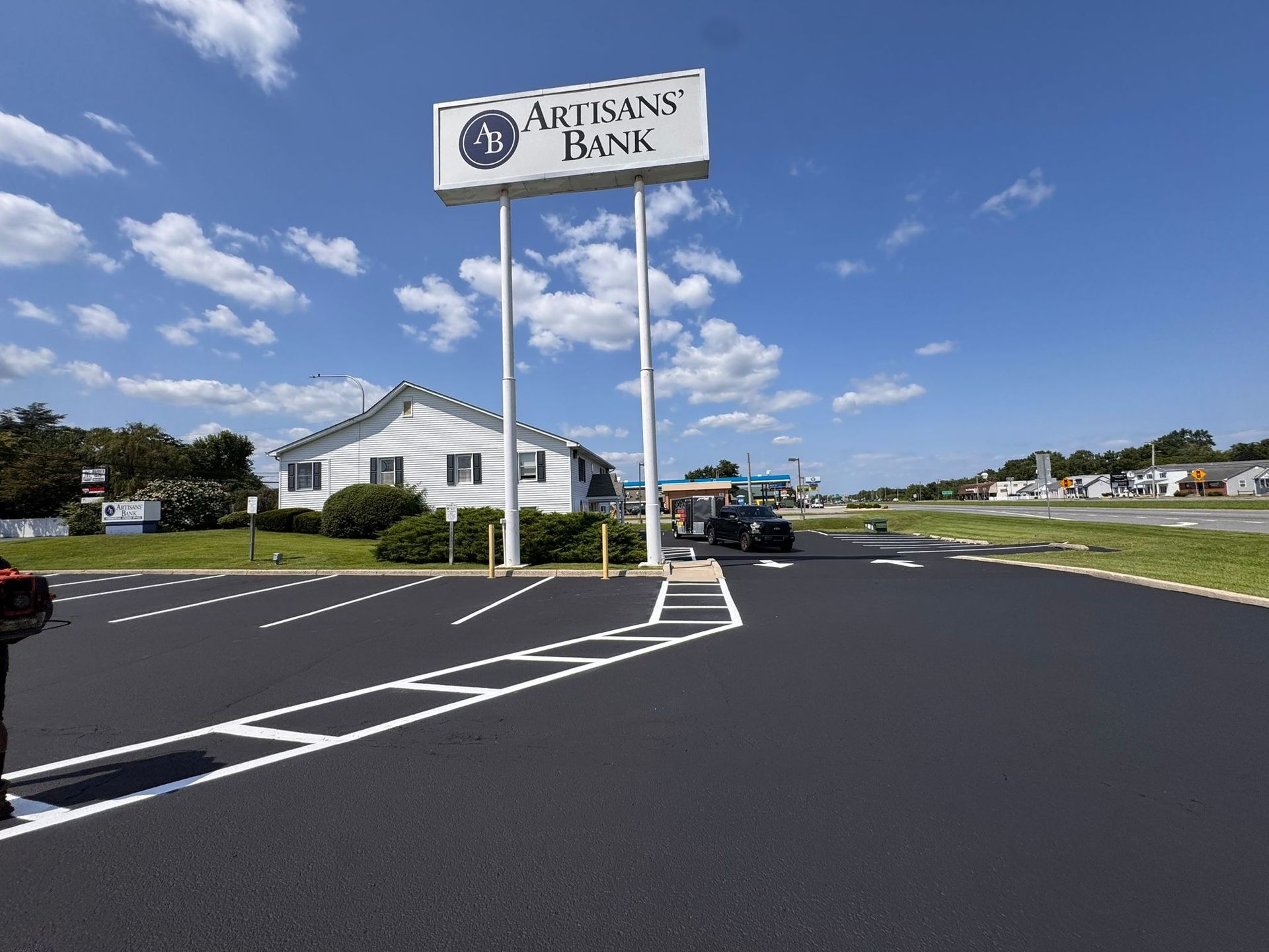 Ariana’s Bank building with a large sign and parking lot under a blue sky