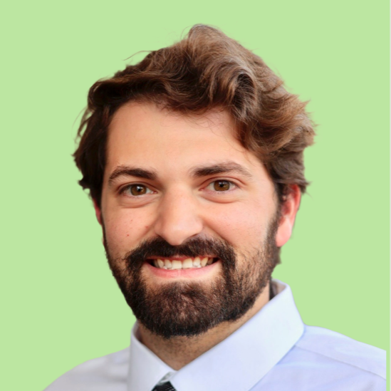 A man in a suit and tie is smiling for the camera
