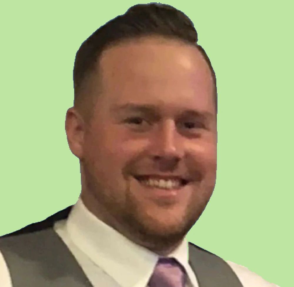 A man in a suit and tie is smiling for the camera.