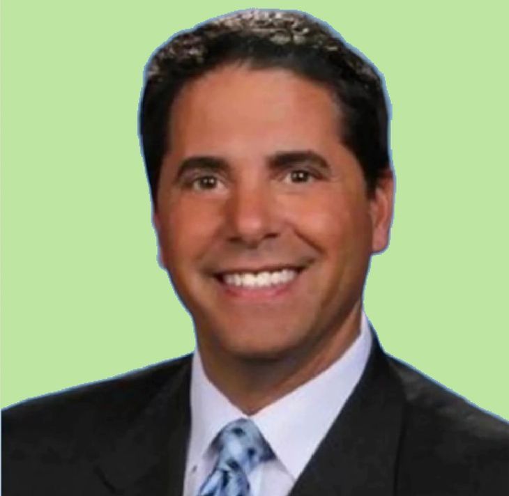 A man in a suit and tie is smiling for the camera.