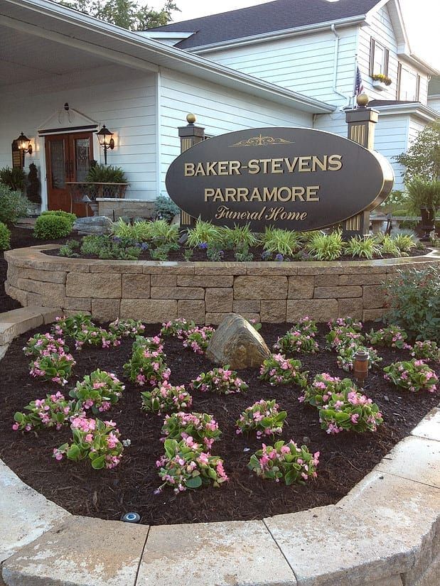 Entrance sign for Baker Stevens Paramoore with a flower bed in front of a house