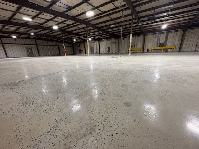 A large empty warehouse with a shiny concrete floor