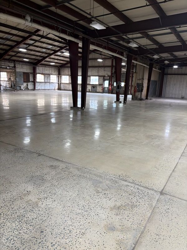 A large empty warehouse with a shiny concrete floor.