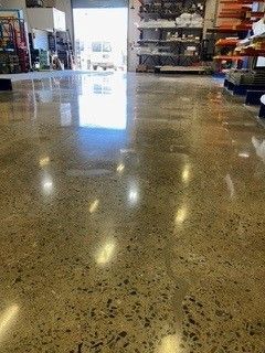 A shiny concrete floor in a store with a lot of shelves.