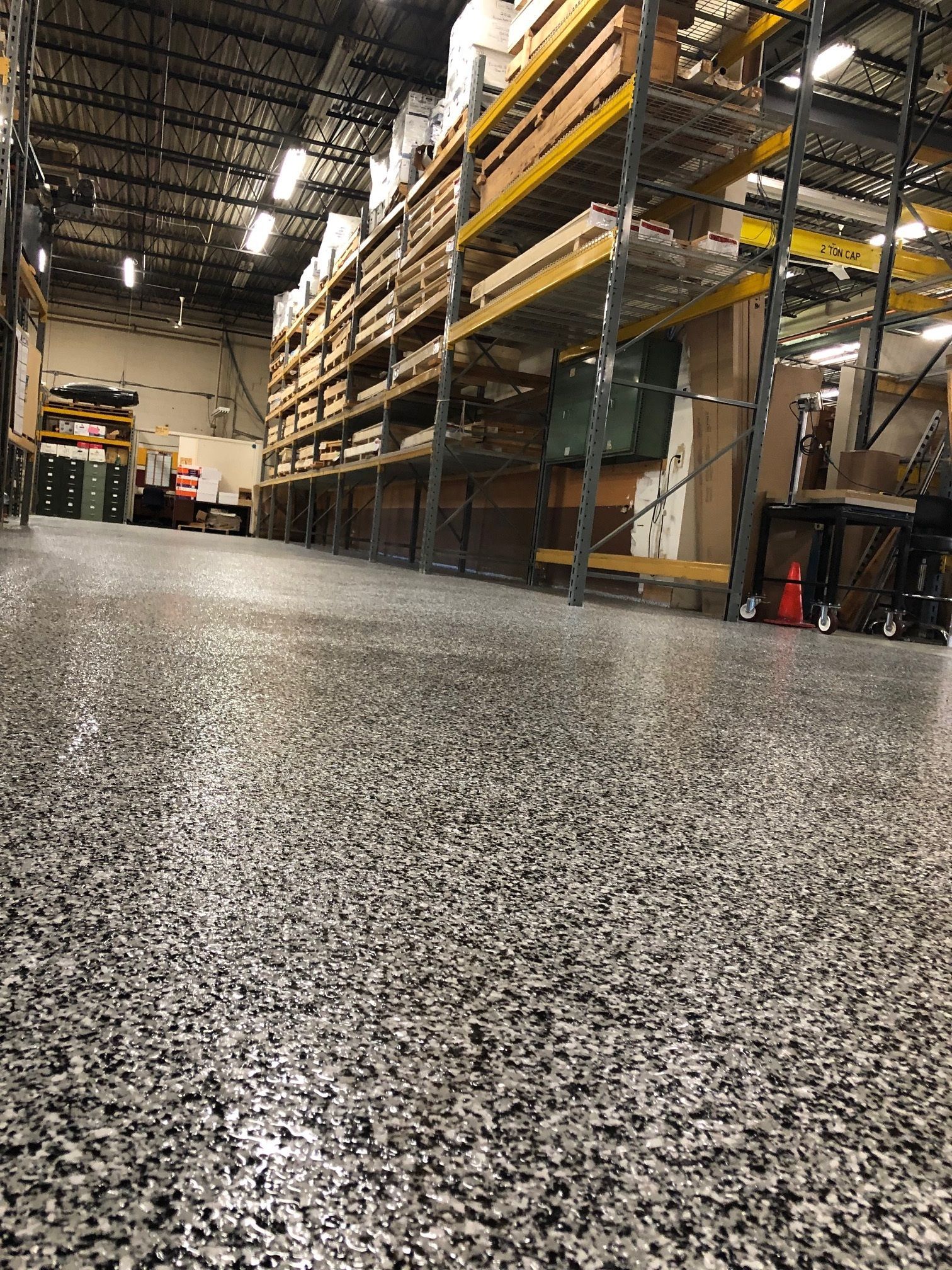 A large warehouse with lots of shelves and boxes on the floor.