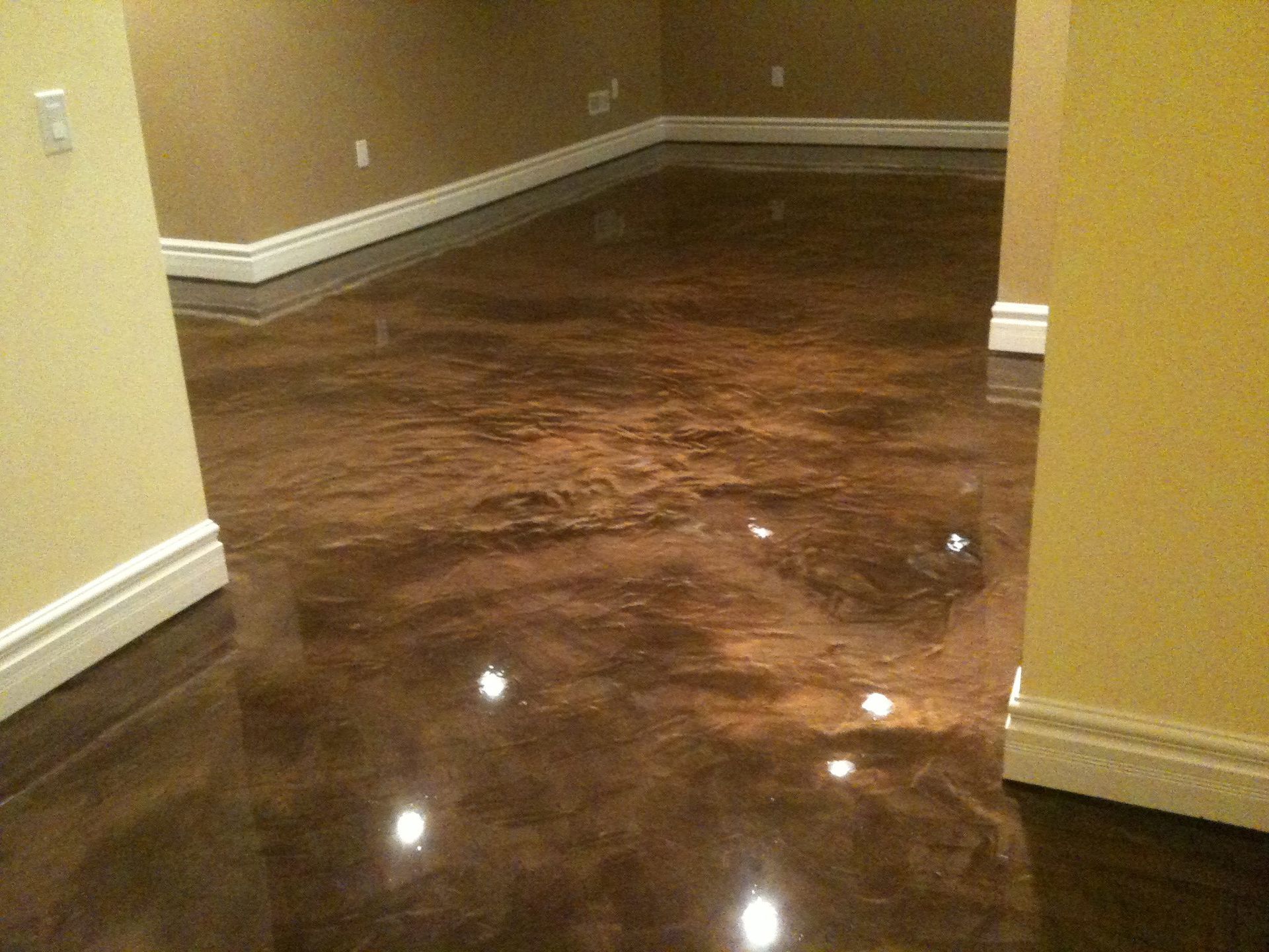 A room with a shiny brown floor and white trim.