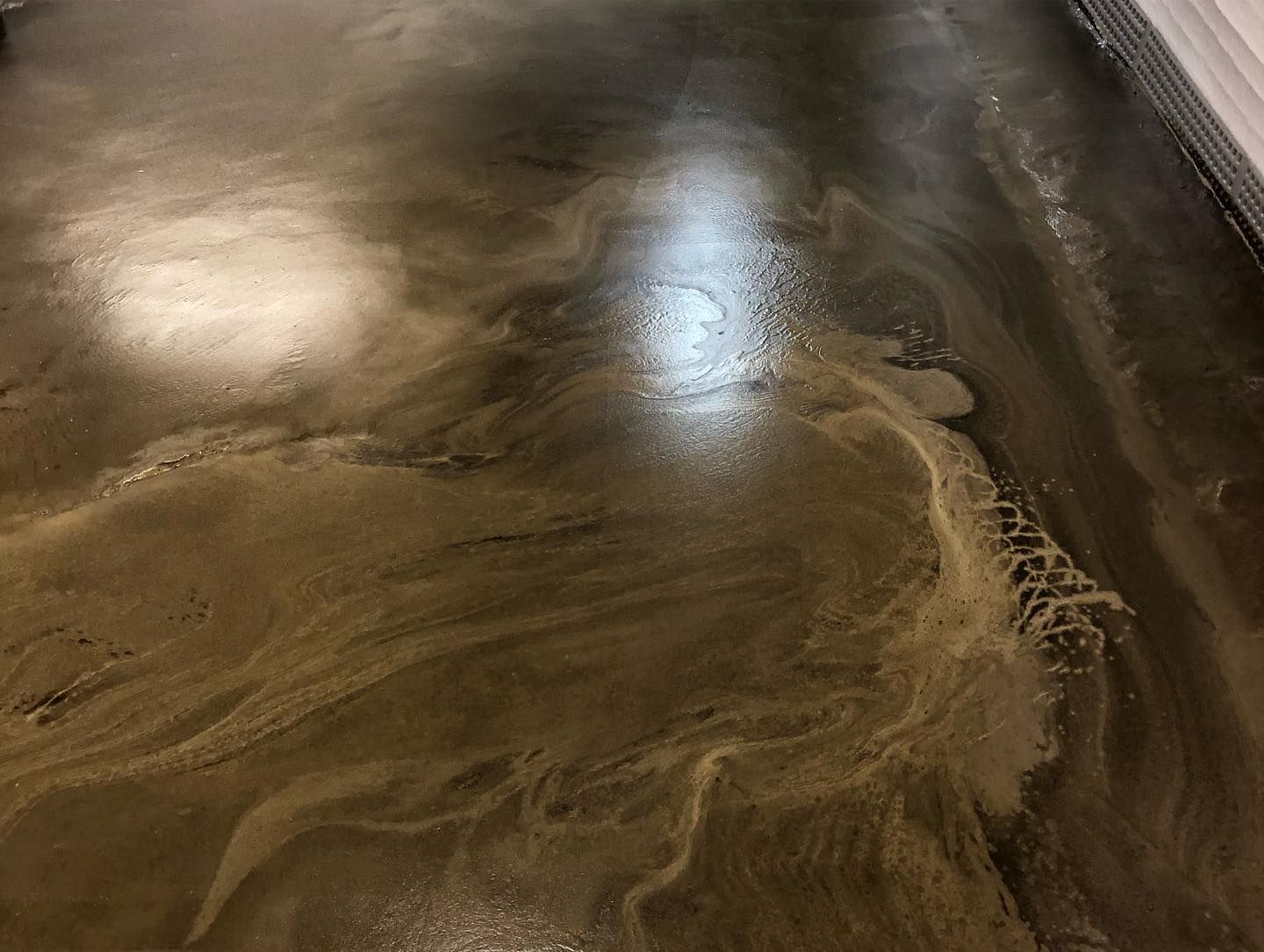 A close up of a shiny concrete floor in a room.