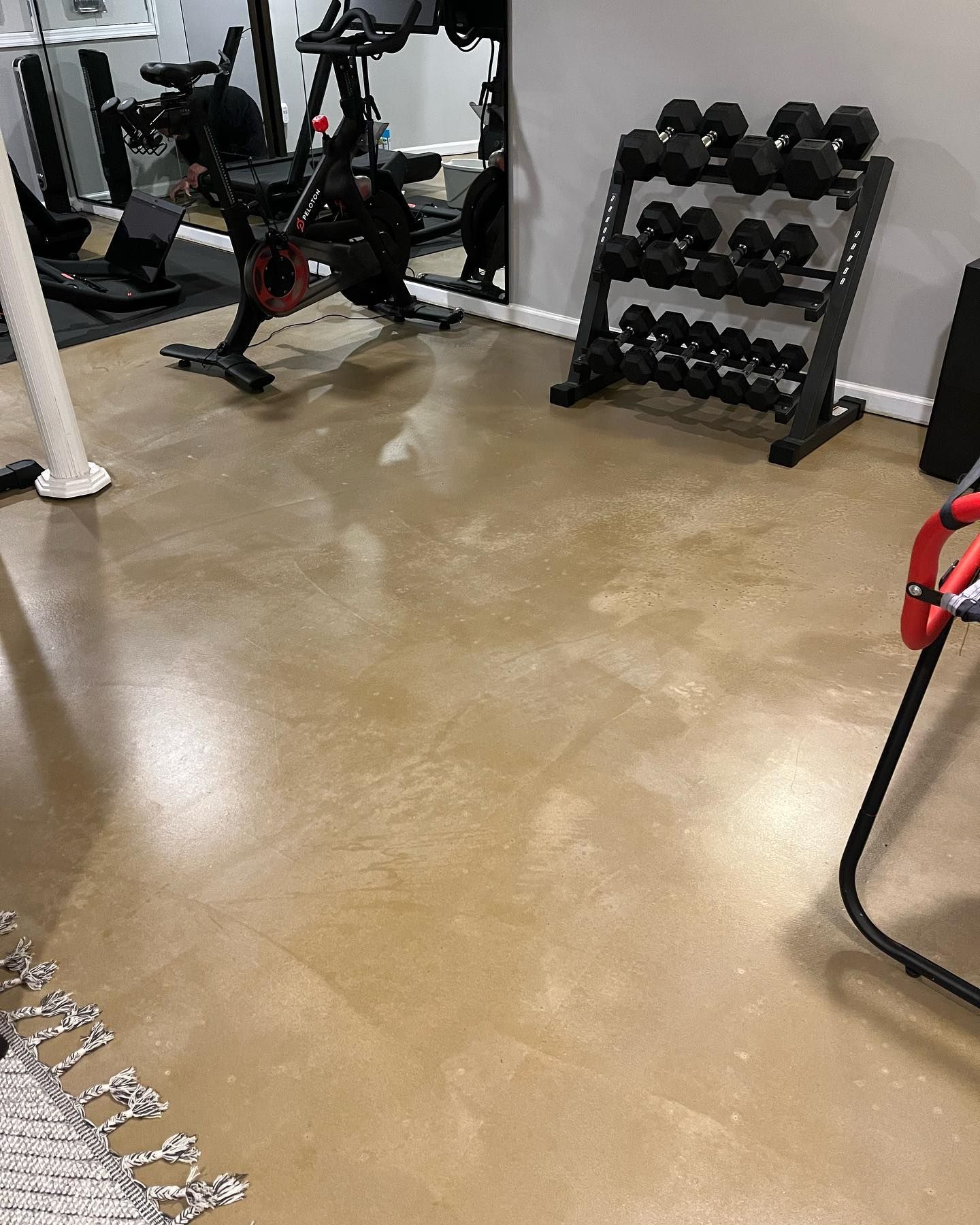 A gym with a bicycle , dumbbells , and other exercise equipment.