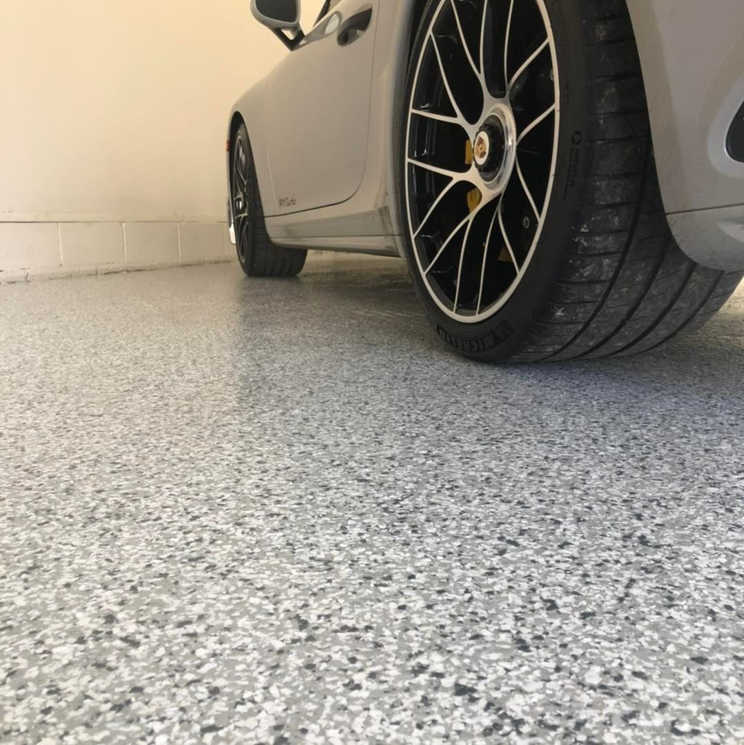 A car is parked in a garage with a concrete floor.