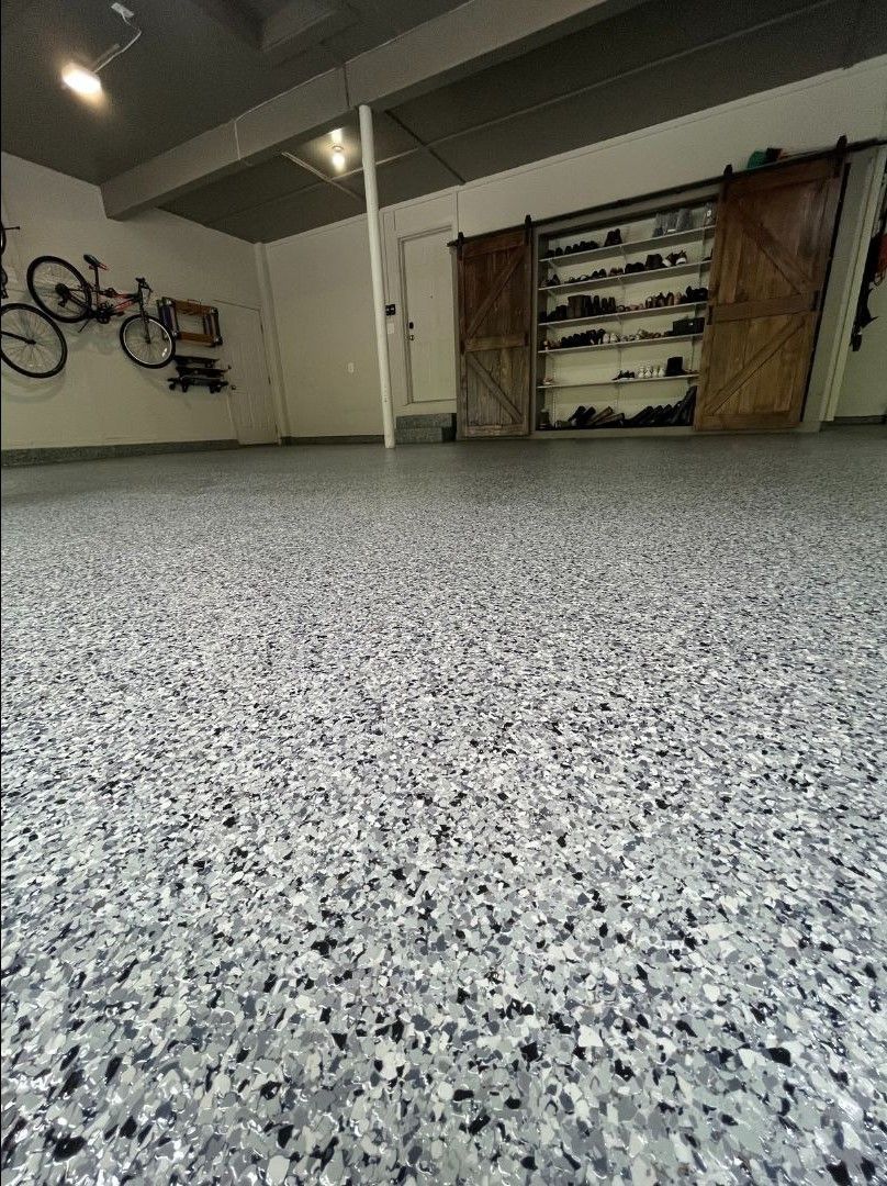 A close up of a gray and black floor in a garage.