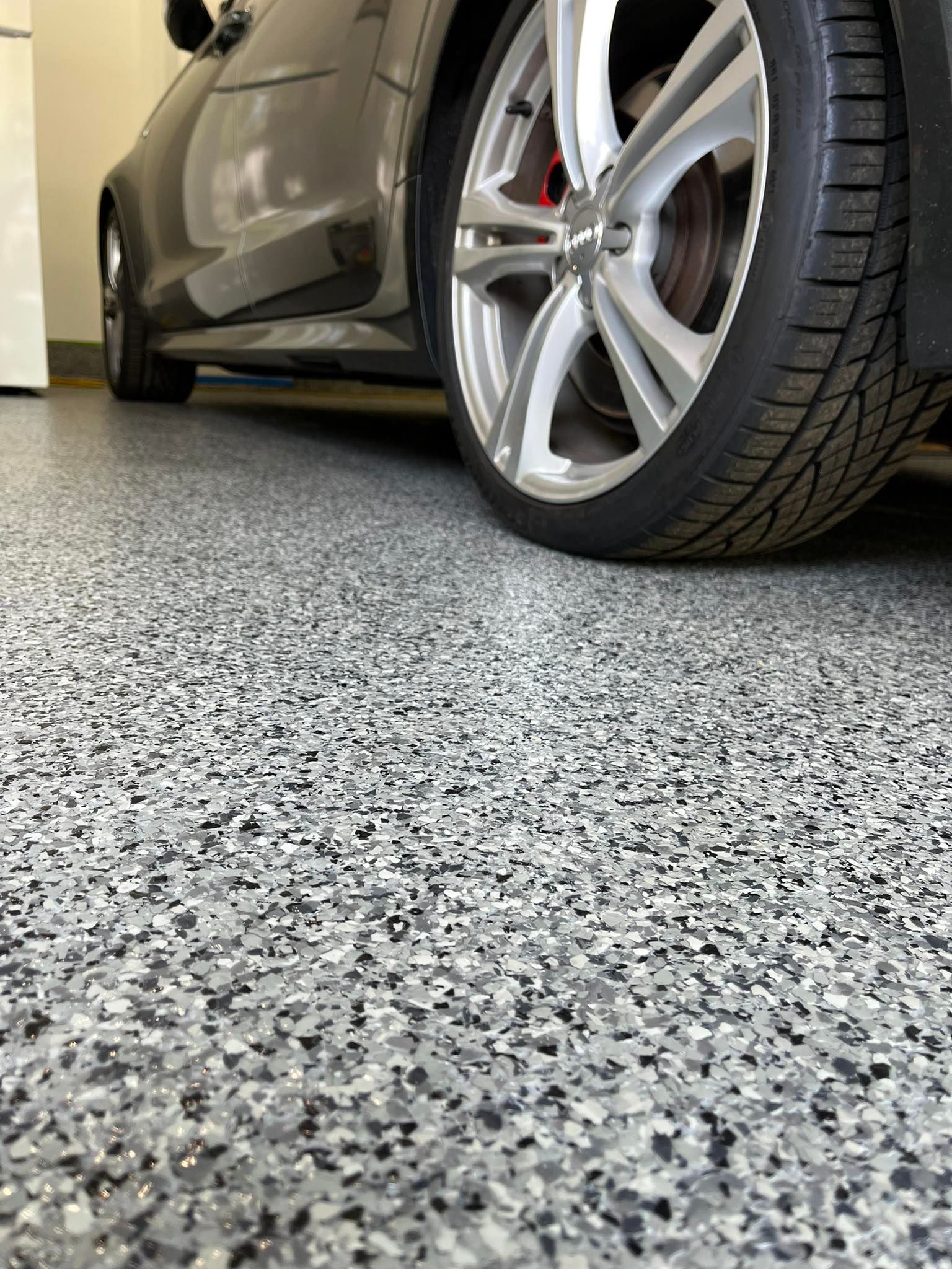 A car is parked in a garage with a concrete floor.
