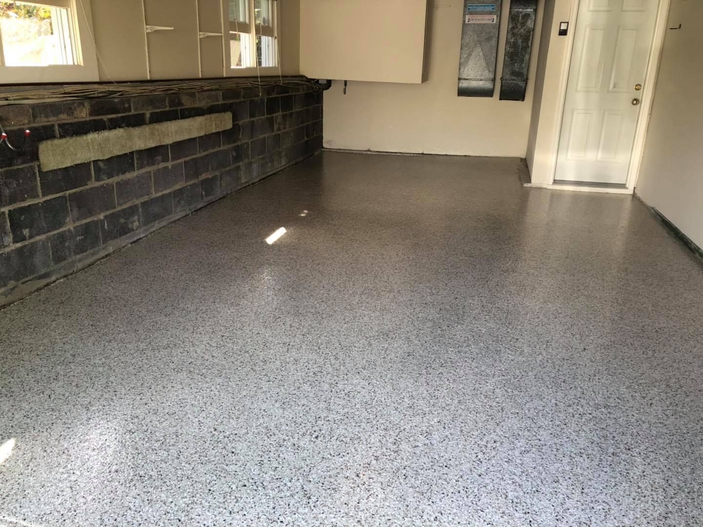 A garage with a concrete floor and a brick wall.