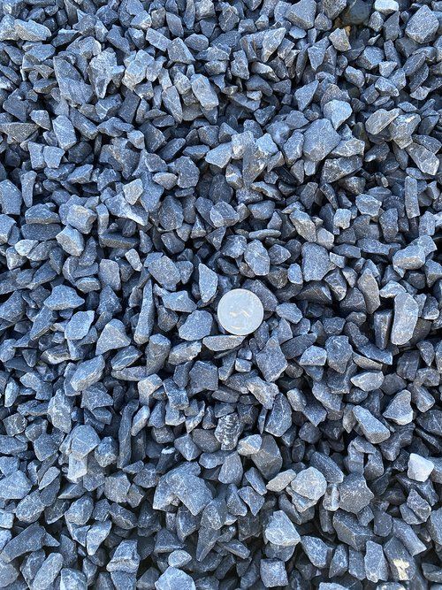 A pile of gravel with a coin in the middle.