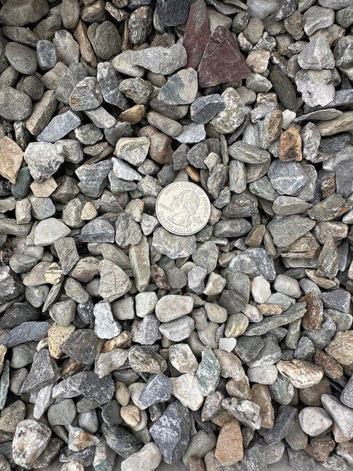 A pile of rocks with a quarter in the middle.