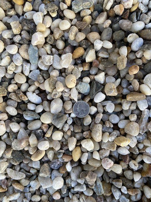 A pile of rocks with a quarter in the middle.