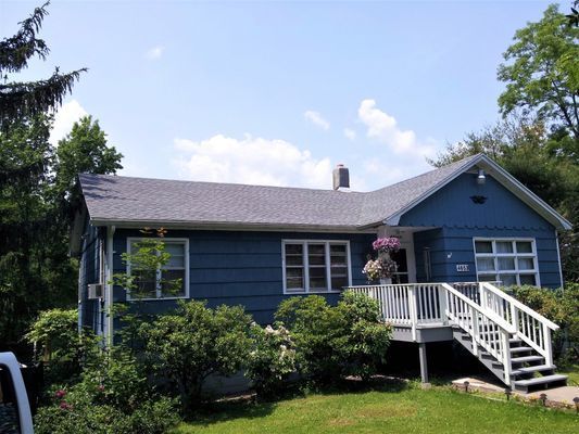 A blue house with a white deck and stairs