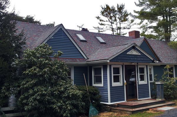 A blue house with a roof that has two skylights on it