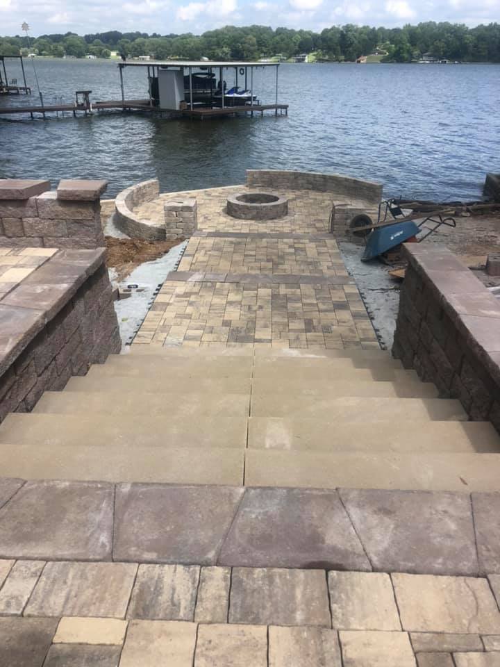 A fire pit is being built on the shore of a lake.