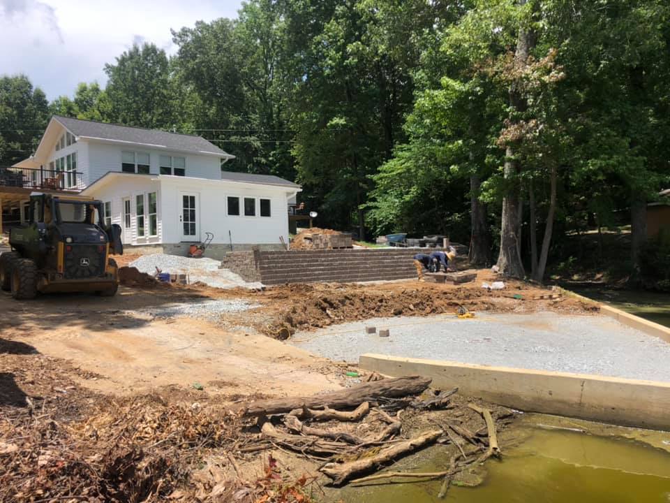 A large white house is being built in the middle of a forest.