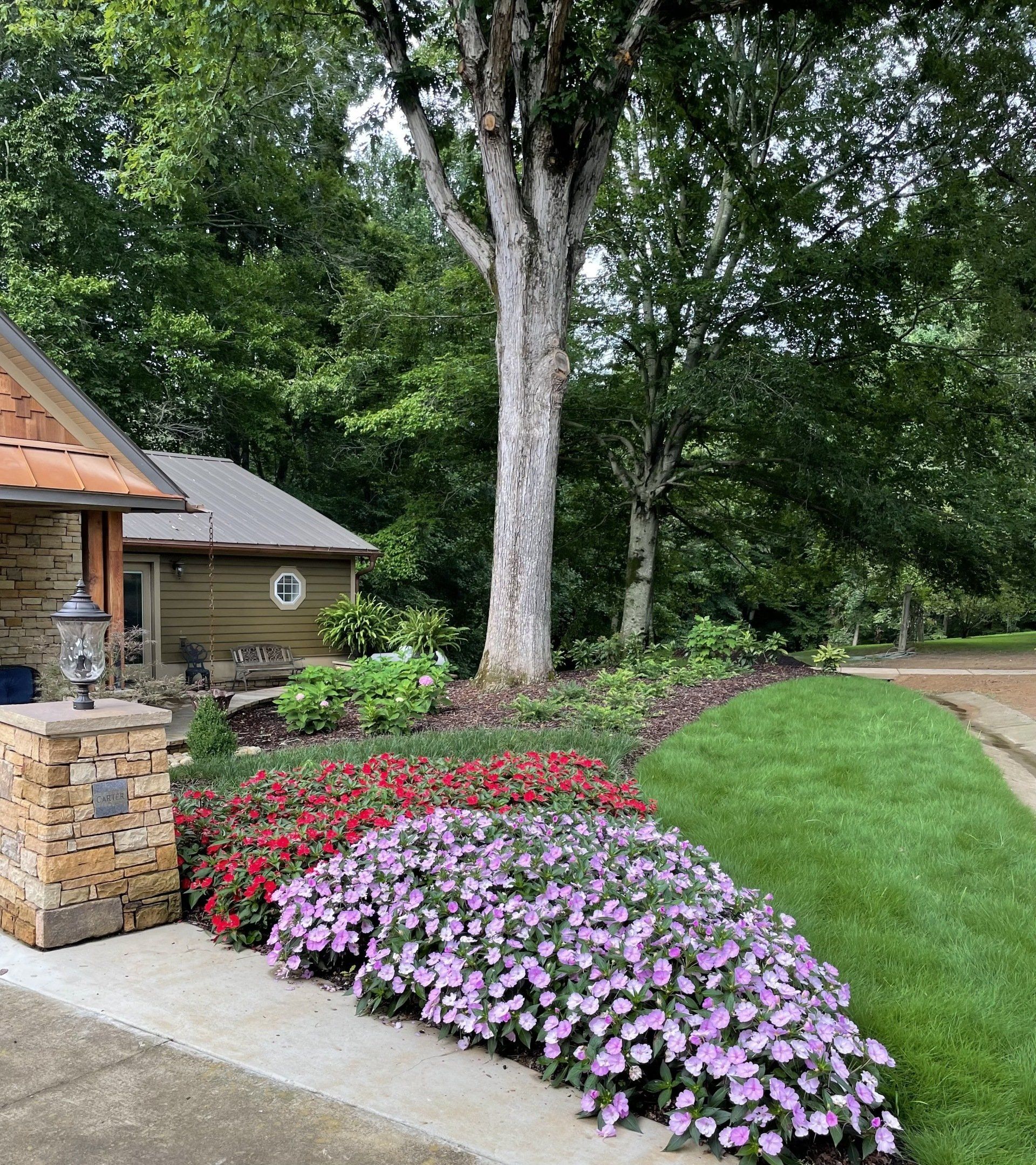 A house with a lot of flowers in front of it.