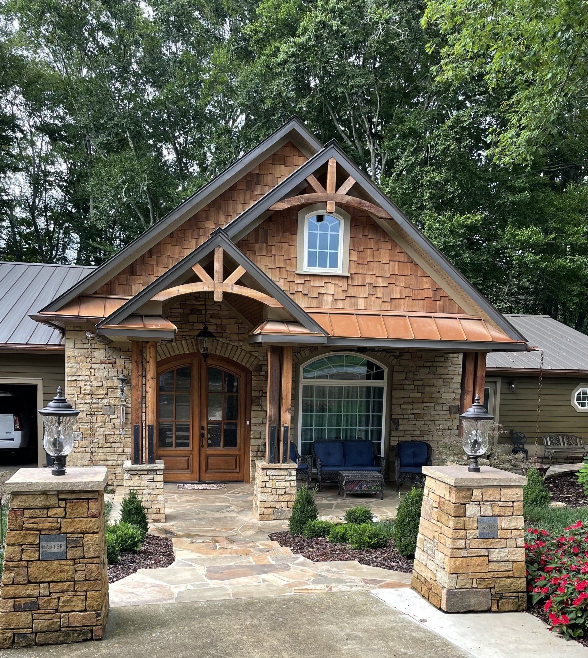 The front of a house with a wooden roof and a stone walkway leading to it.