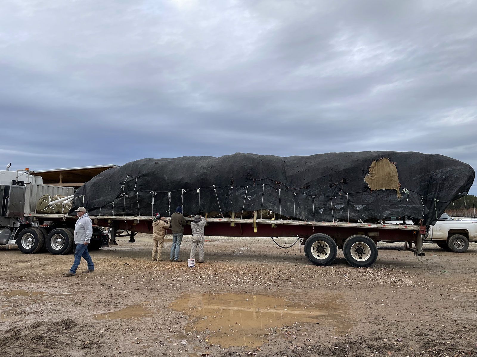 A group of people are standing next to a large trailer.