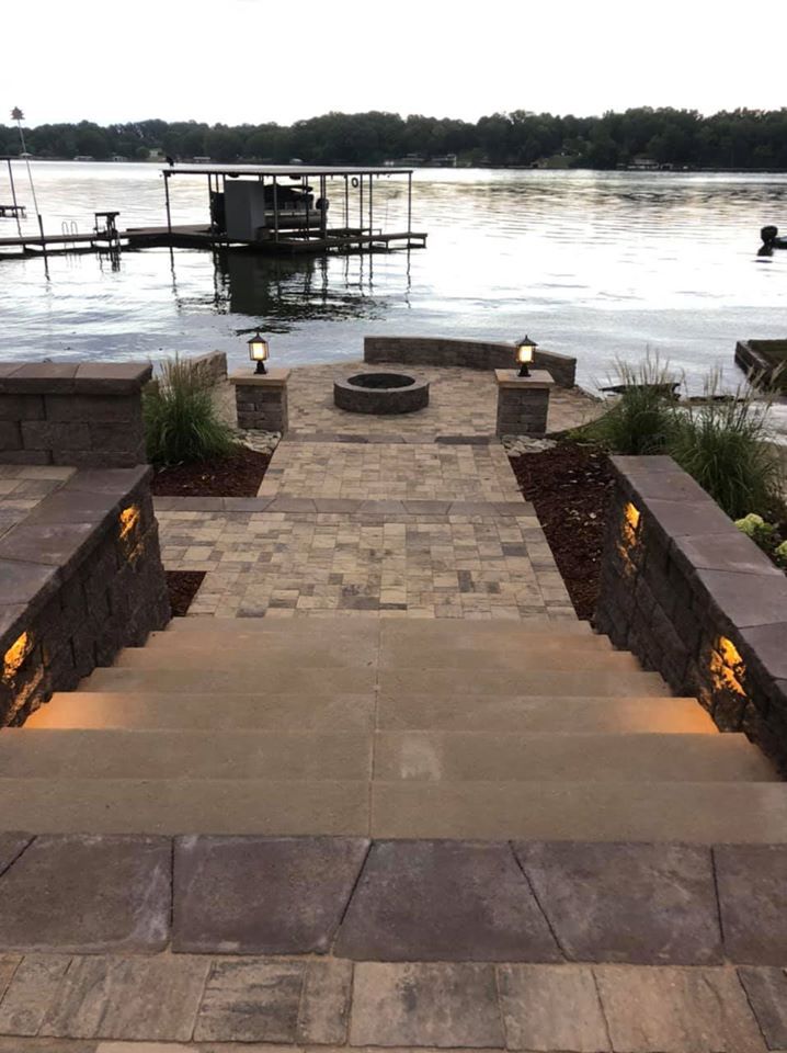 A staircase leading up to a lake with a fire pit.