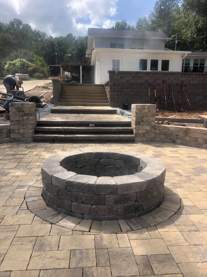 A fire pit is sitting on a patio in front of a house.