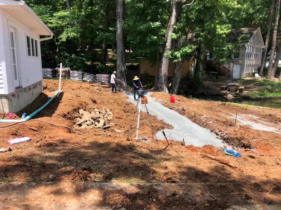 A concrete walkway is being built in the backyard of a house.