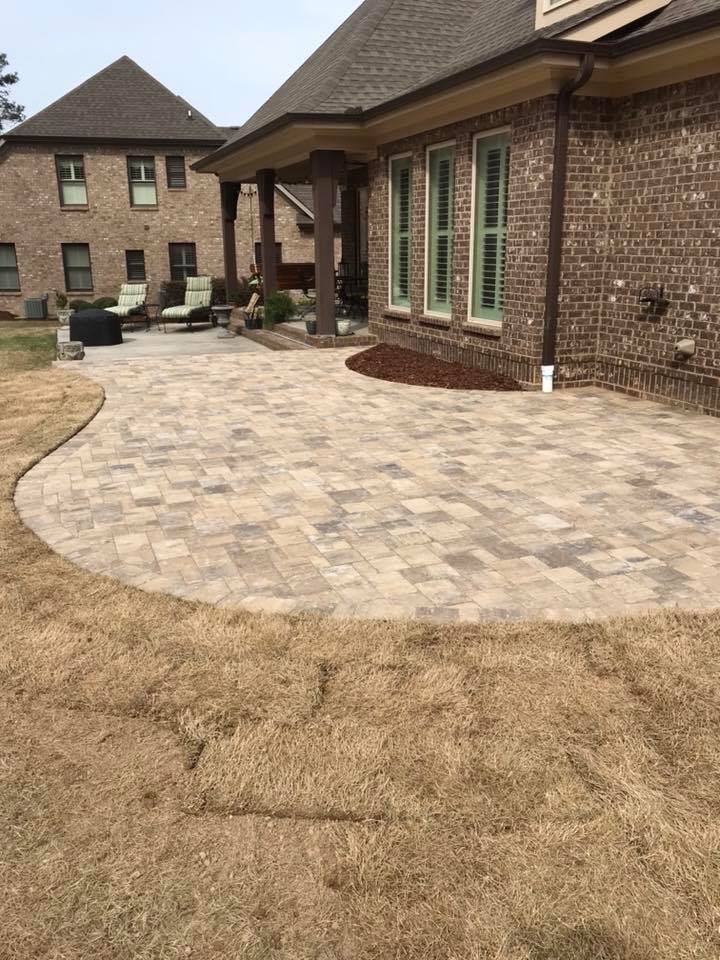 A large brick house with a patio in front of it.