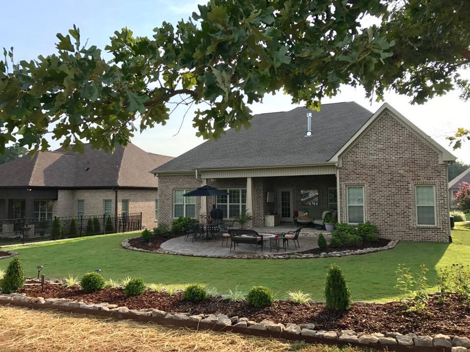 A large brick house with a patio area in front of it