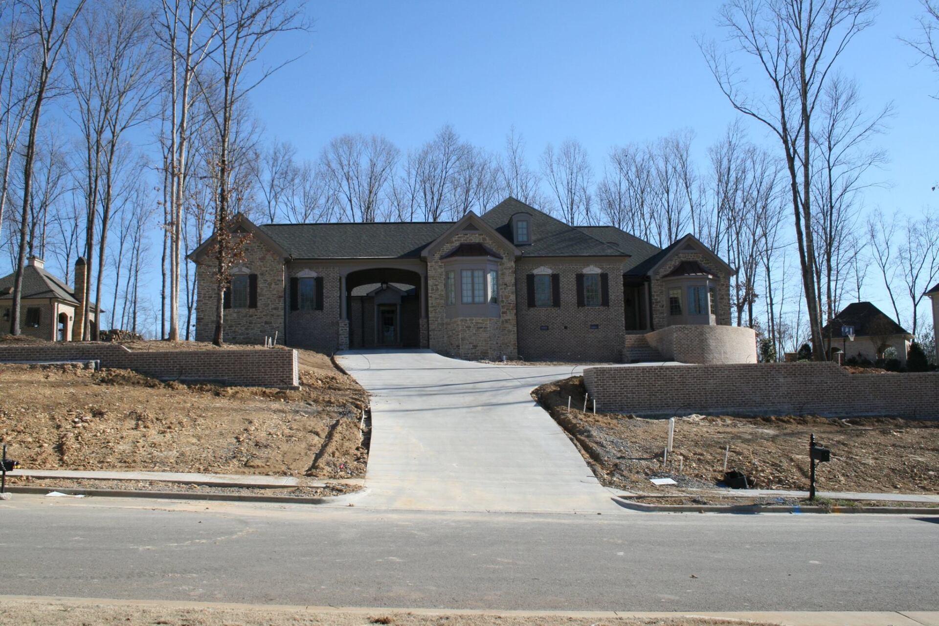 A large house with a concrete driveway leading to it