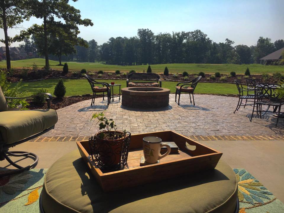 A patio with a fire pit and a tray on it