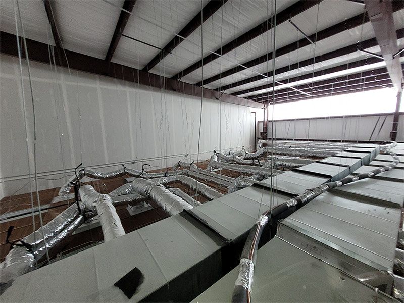 A large room with a lot of pipes hanging from the ceiling.