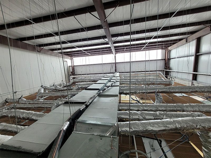 A large room with a lot of pipes hanging from the ceiling.