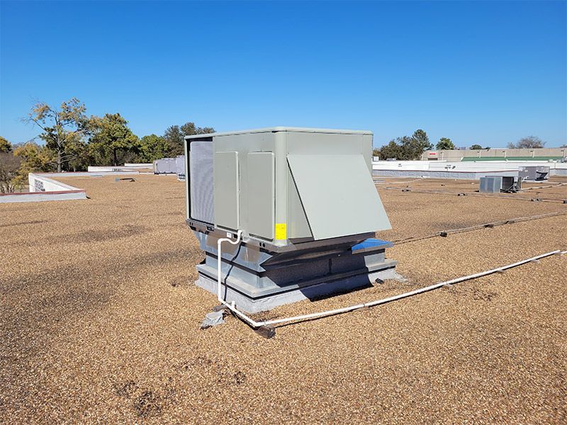 A large air conditioner is sitting on top of a roof.