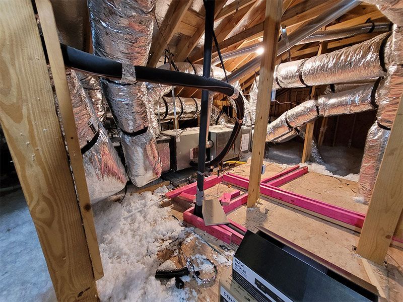 There are a lot of pipes in the attic of a house.