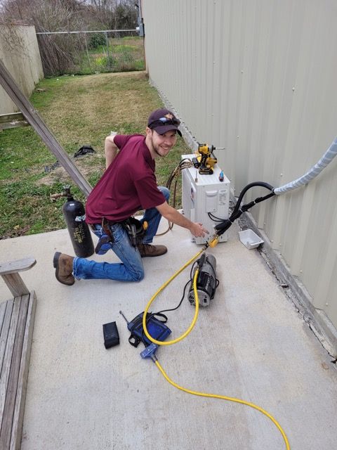 A man is working on an air conditioner outside of a building