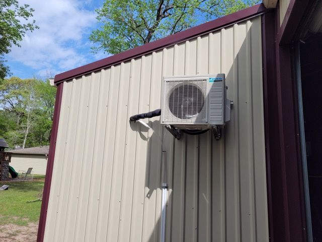 An air conditioner is mounted on the side of a building.