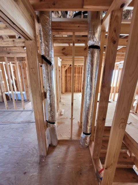 A building under construction with a lot of wooden beams and pipes