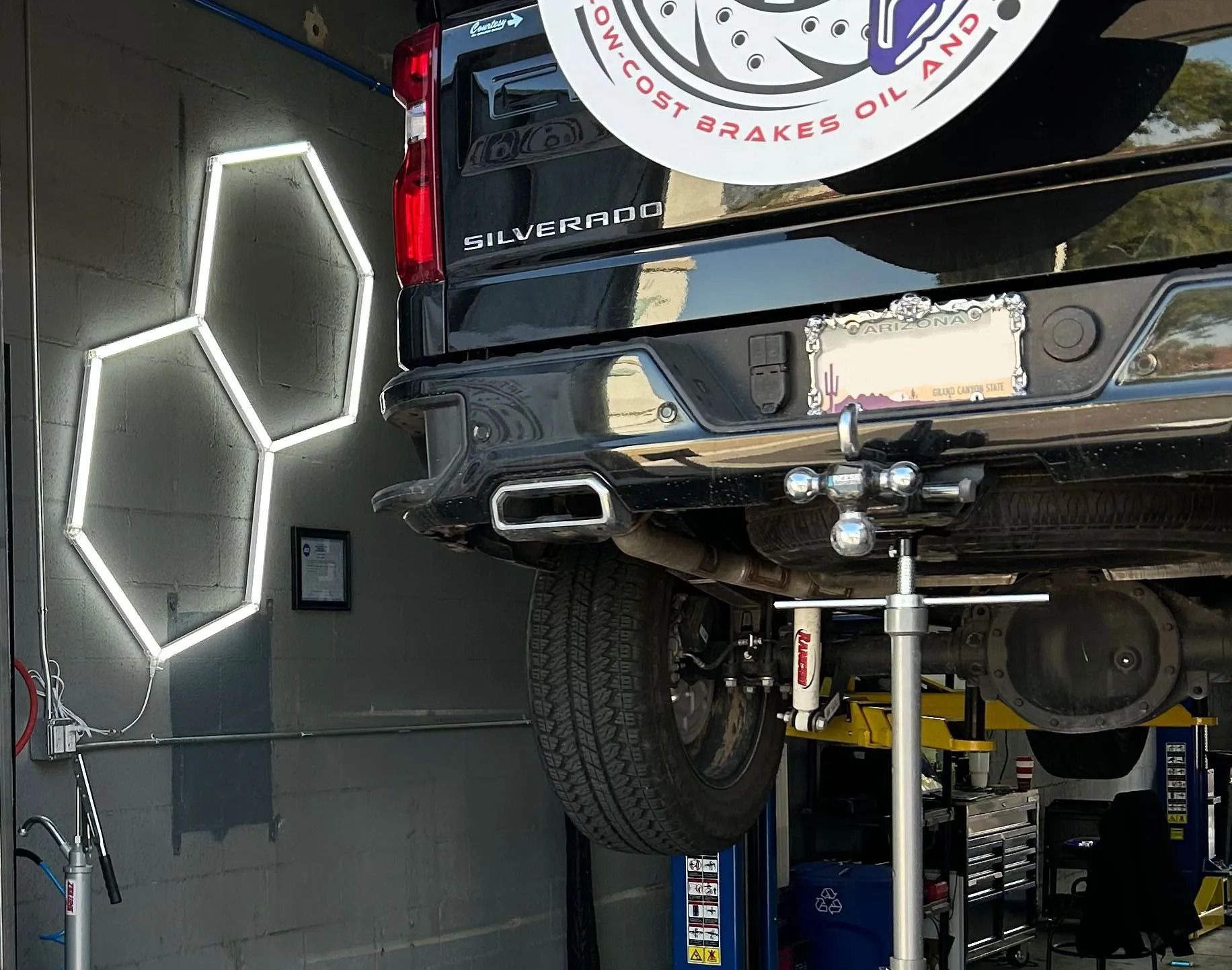 Lift 'n Wrench auto shop exterior with neon lights, car lift, and sign, featuring a yellow car graphic.