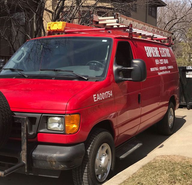 Red Van Service truck parked in a driveway, with a ladder on the roof and bold white lettering on the side