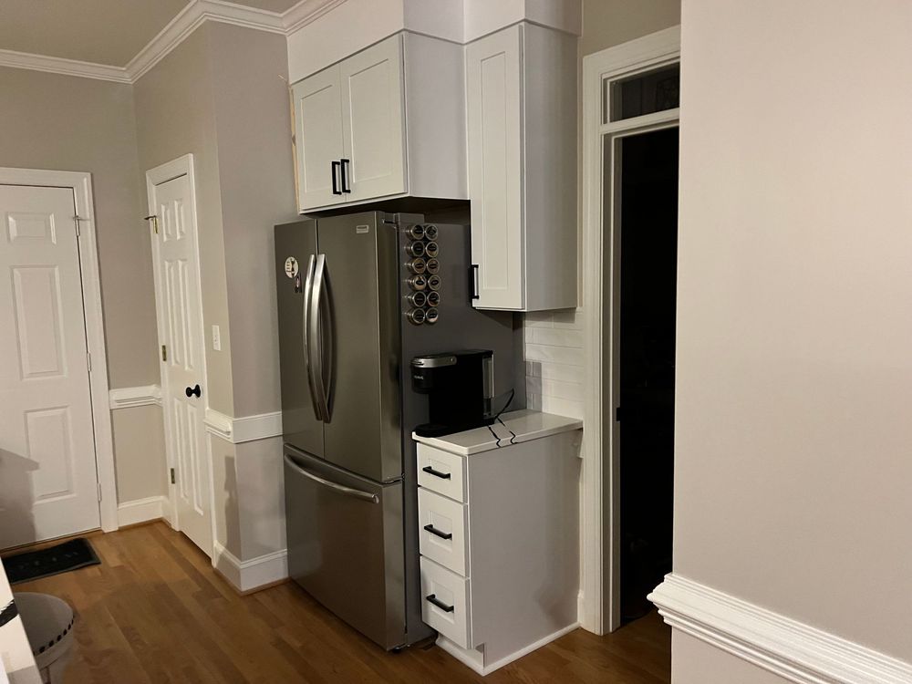 A kitchen with stainless steel appliances and white cabinets.